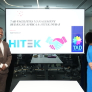 Javeria Aijaz the Managing Director of HITEK LLC in the UAE - Dubai standing in the meeting room near presentation screens showing partnership with TAD